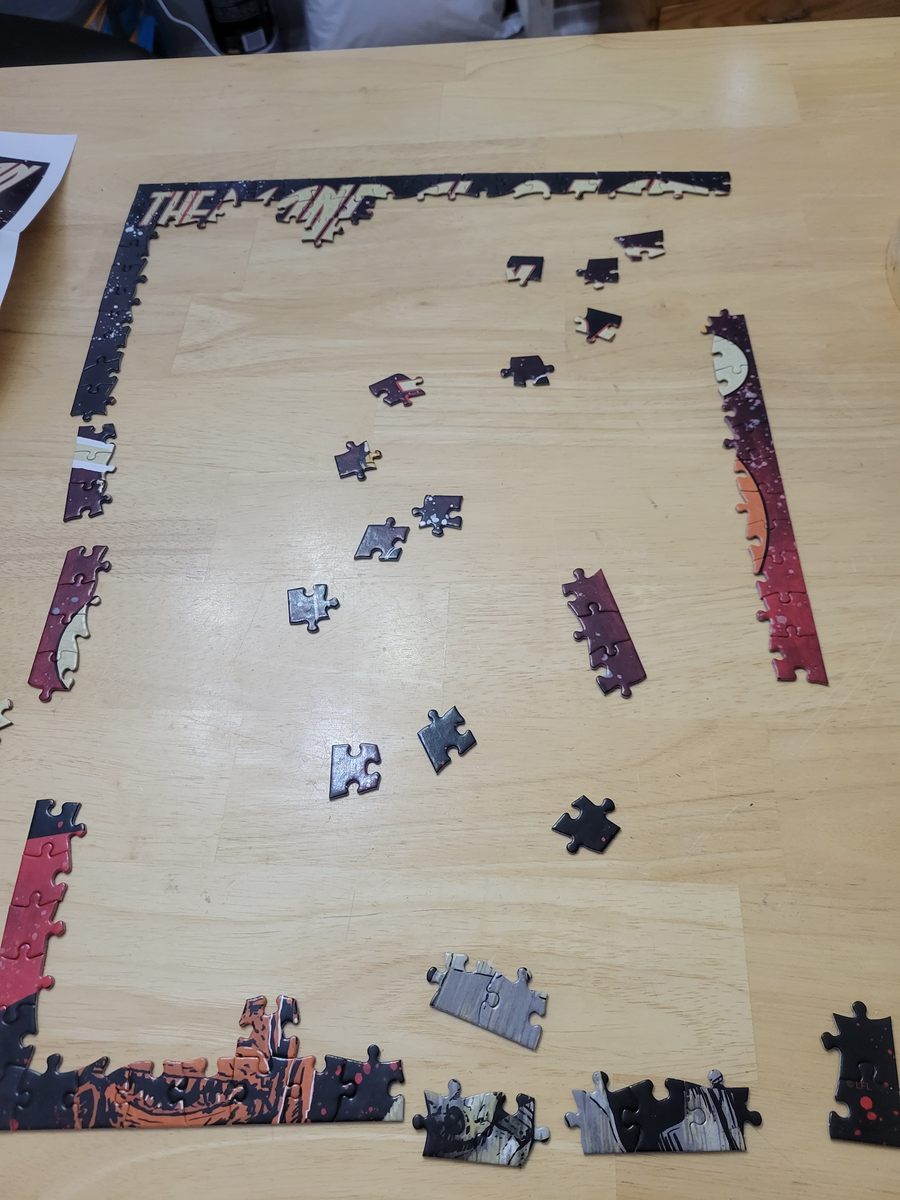 An incomplete puzzle with most of the edges placed together, but there are several gaps in the border.